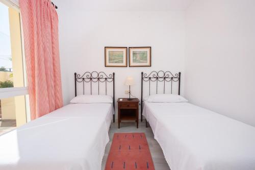deux lits jumeaux dans une chambre avec fenêtre dans l'établissement Las Palmeras Beach with Community Pool, à La Herradura