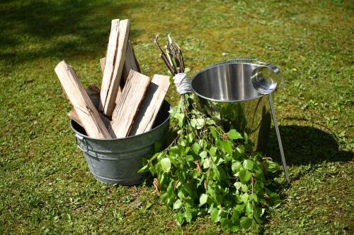 a bucket of wood and a plant in the grass at Lakeside Hotels Kuore in Kitashiobara