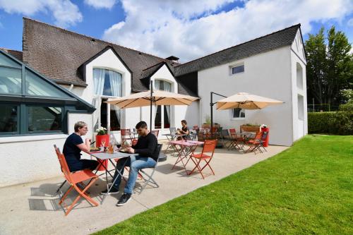 two people sitting at a table in a yard at ibis Brest Kergaradec in Brest