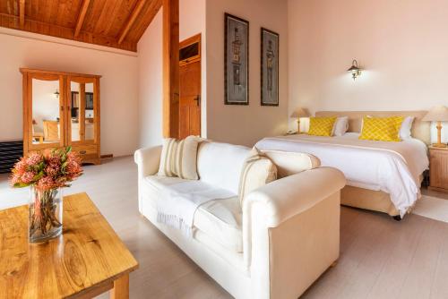 a living room with a bed and a couch at Paquita Self Catering Holiday House in Knysna