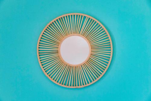 a plate with a mirror on a blue wall at Villa Curiazzi Guesthouse Viale la Pelosa 16 in Stintino