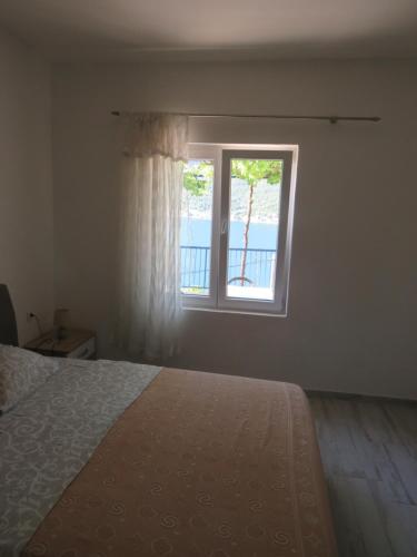 a bedroom with a bed and a window at Apartments Jovanović in Perast