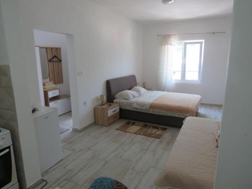 a small bedroom with a bed and a window at Apartments Jovanović in Perast
