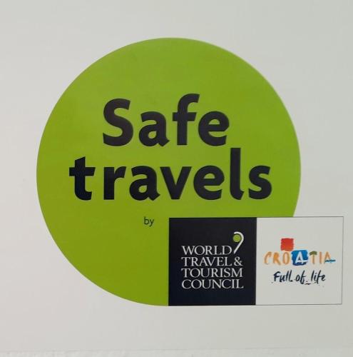 a green sign with the words safe travels on it at Apartman Vida in Pula