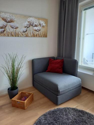 a living room with a couch with a red pillow at Lutakko Apartment 2 with free parking in Jyväskylä