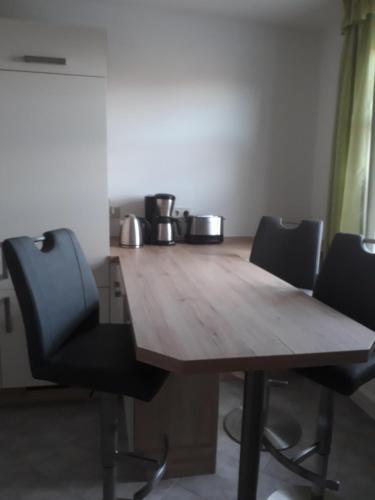 een houten tafel met vier stoelen eromheen bij Ferienwohnung Steinweg 28 in Quedlinburg