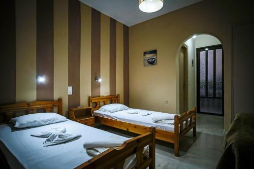 a room with two beds and a hallway at Nadia Studios in Kalamaki