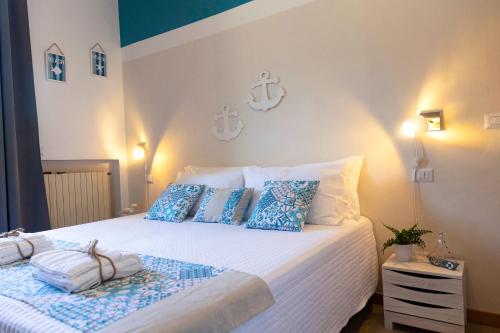a bedroom with a bed with blue and white pillows at Villa Curiazzi Guesthouse Viale la Pelosa 16 in Stintino