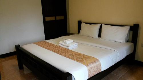 een slaapkamer met een bed met twee handdoeken erop bij The Dome Residence in Chiang Mai