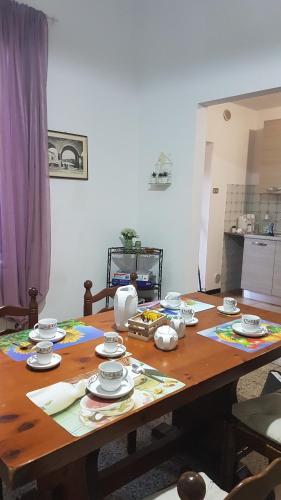 a wooden table with plates and dishes on it at Casa Clelia in Monsummano