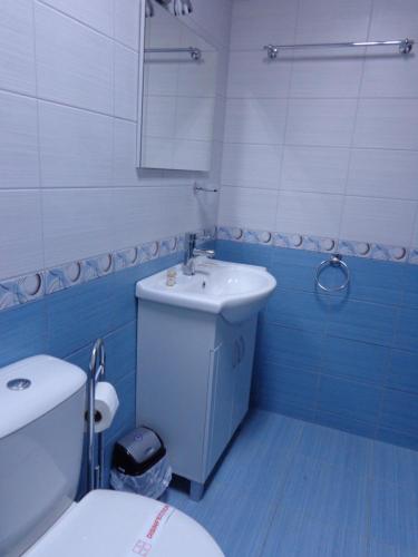 a blue and white bathroom with a toilet and a sink at Къща за гости А. Б. В. in Nesebar