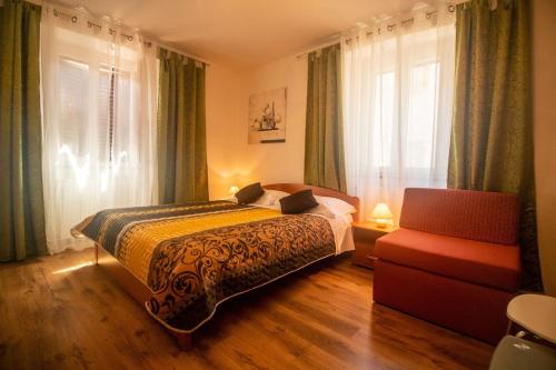 sypialnia z łóżkiem, krzesłem i oknem w obiekcie Guest House Franko w mieście Bale