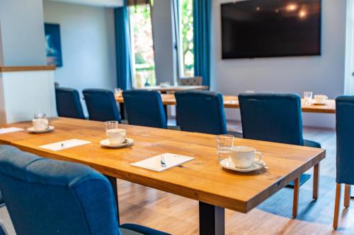 a conference room with a wooden table and chairs at Stratmanns Haus am See in Lembruch
