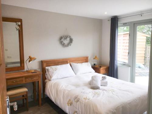 a bedroom with a bed and a desk and a mirror at Abergafren Lodge in Porthmadog