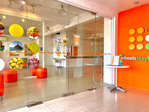 a glass display case in a store with orange walls at Islands Stay Hotels Mactan in Mactan