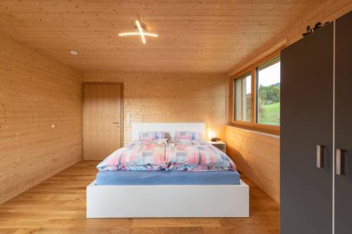 a bedroom with a bed in a room with wooden walls at Rosenhaus 1 in Schwarzenberg