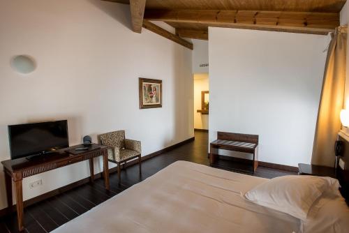 1 dormitorio con cama, escritorio y TV en Palacio del Infante Don Juan Manuel Hotel Spa, en Belmonte