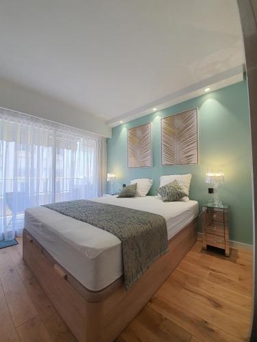 une chambre avec un grand lit aux murs verts dans l'établissement Branly 4, by Welcome to Cannes, à Cannes