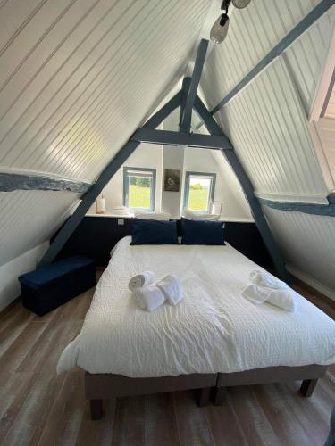 une chambre avec un lit blanc dans un grenier dans l'établissement Cottage Lucas, à Rue