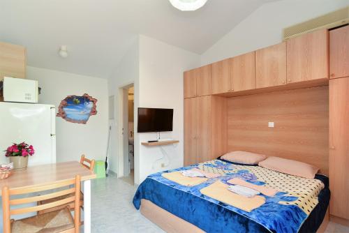 a bedroom with a bed and a table and a television at Apartments Marijan 105 in Pula