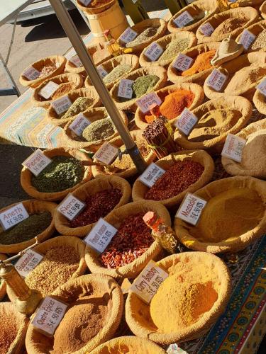 une présentation de différentes épices dans des paniers sur une table dans l'établissement Joli studio à deux pas de la place du forum, à Arles
