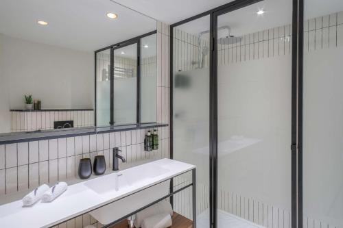 a bathroom with a sink and a glass shower at Melia White House Hotel in London