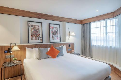 a bedroom with a large white bed and a window at Melia White House Hotel in London