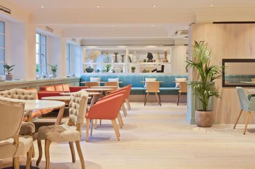 a restaurant with tables and chairs in a room at Meliá White House Hotel Apartments in London