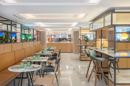 a restaurant with tables and chairs and windows at Meliá White House Hotel Apartments in London