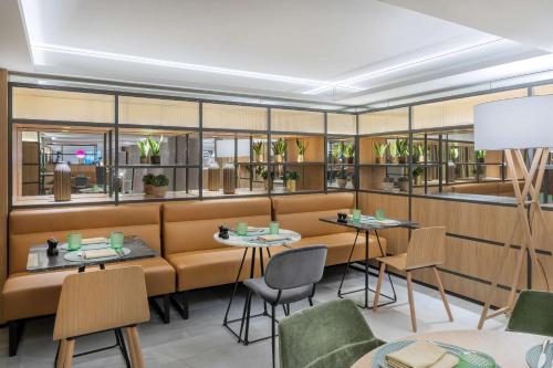 a restaurant with tables and chairs and windows at Meliá White House Hotel Apartments in London