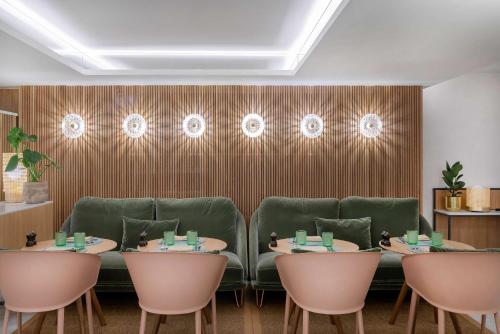 a restaurant with four tables and green chairs at Meliá White House Hotel Apartments in London