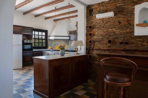 a kitchen with a wooden island in the middle of a room at Villa Velissarios: wonderful villa next to beach in Aegina Town