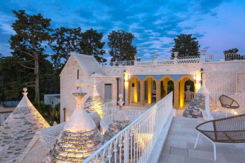 a home with a staircase leading to a mansion at Borgo dei Lecci Puglia in Selva di Fasano