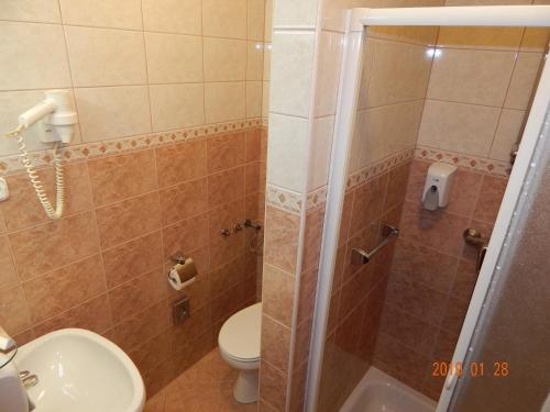 a bathroom with a shower with a toilet and a sink at Panorama Hotel Noszvaj in Noszvaj