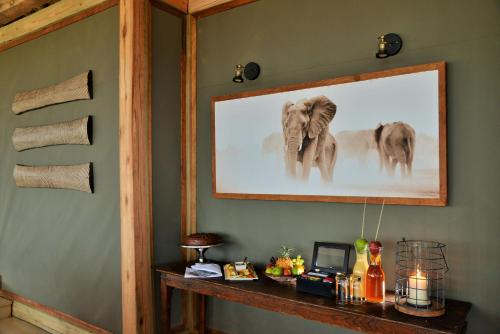 a room with a picture of elephants on the wall at Nogatsaa Pans Chobe Lodge in Kasane