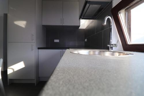 a kitchen counter with a sink and a window at Maison Lunette in Koksijde