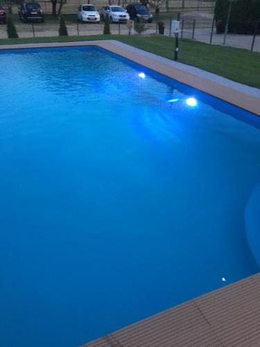 a large blue swimming pool with lights on it at Bor-Vendégház in Kiskőrös
