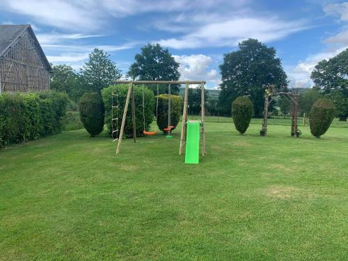 a park with a swing set in the grass at Maison la touchardiere in Barenton