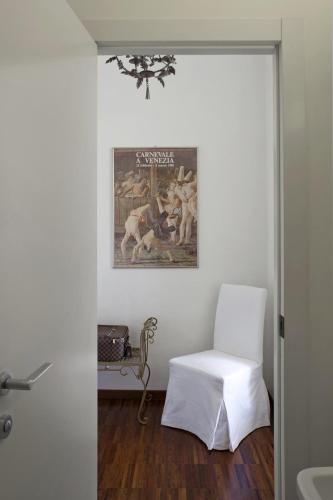 a room with a white chair and a painting on the wall at La Canarina Bed & Breakfast in Como