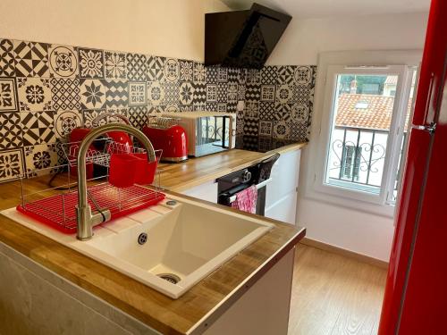 uma cozinha com um lavatório e uma bancada em Appartement Prox Lycée Arago em Perpignan