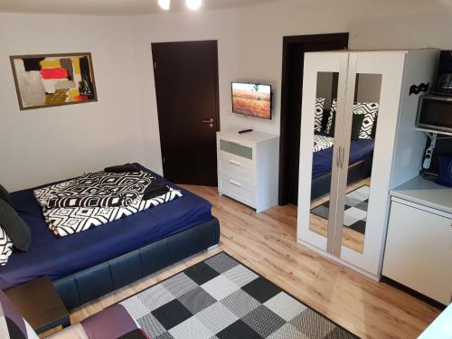 een kleine slaapkamer met een bed en een spiegel bij Honfoglalas Apartment in Bük