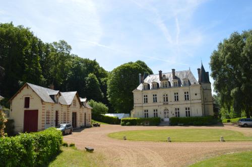 une vieille maison avec une voiture garée devant elle dans l'établissement Château de Vallagon, à Bourré