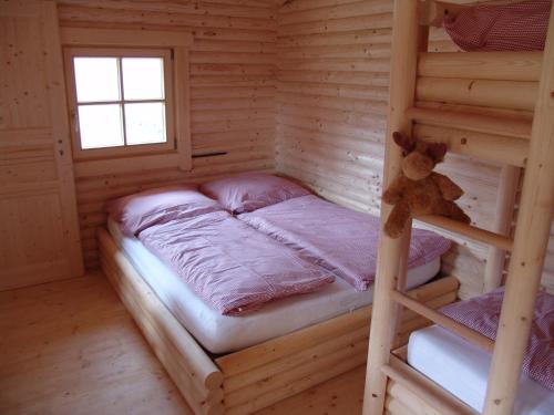 a bedroom with a bunk bed in a log cabin at Baumhaus Hotel Voglsam in Schönau