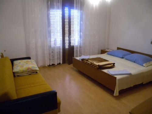 a bedroom with a bed and a couch at Apartment Kampor 10 in Kampor