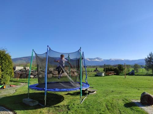 a person jumping on a trampoline in a field at Willa Kolorowa Chata 6 km Od Karpacza in Mysłakowice