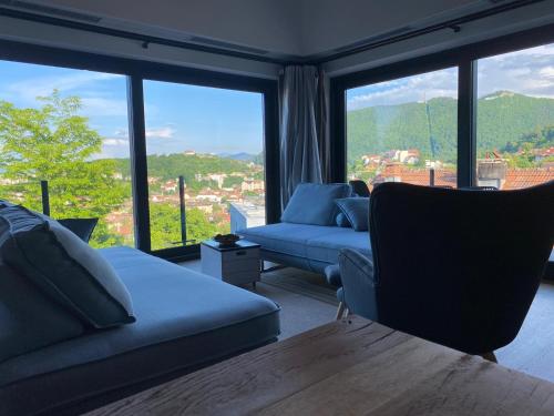 un soggiorno con divani e una grande finestra di The Pines Boutique Villa a Braşov