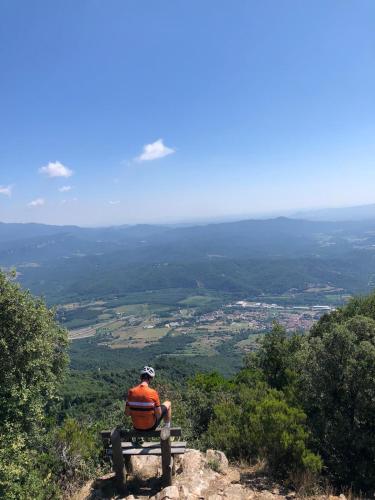 a man sitting on a bench on top of a mountain at Hostal Tarrés in Anglés