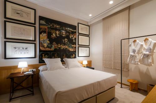 a bedroom with a bed and a wall with pictures at Hotel Margot House Barcelona in Barcelona