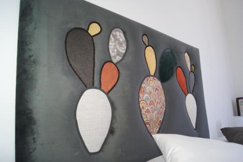 a headboard with four different colored mirrors on it at Gibilrossa BeeHill in Misilmeri
