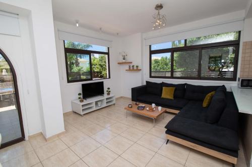ein Wohnzimmer mit Sofa und Fernseher in der Unterkunft Mylos 9 in Protaras